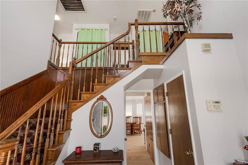 wooden staircase leading to the upstairs landing and an entry way to kitchen on first floor