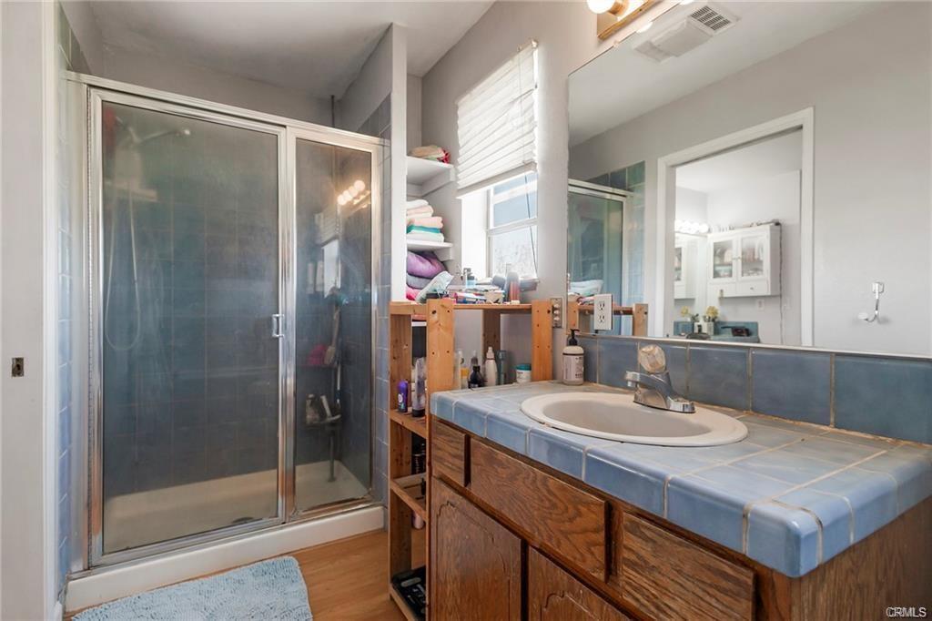 Bathroom with standing shower and blue tile vanity