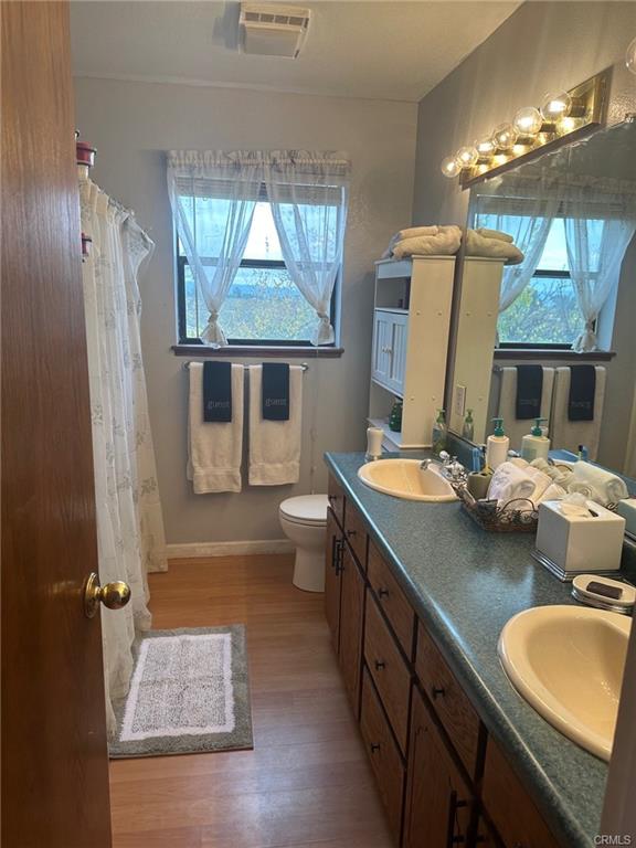 bathtub, toilet, dual sinks in bathroom