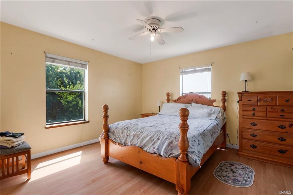 large bedroom with hardwood floors and yellow walls